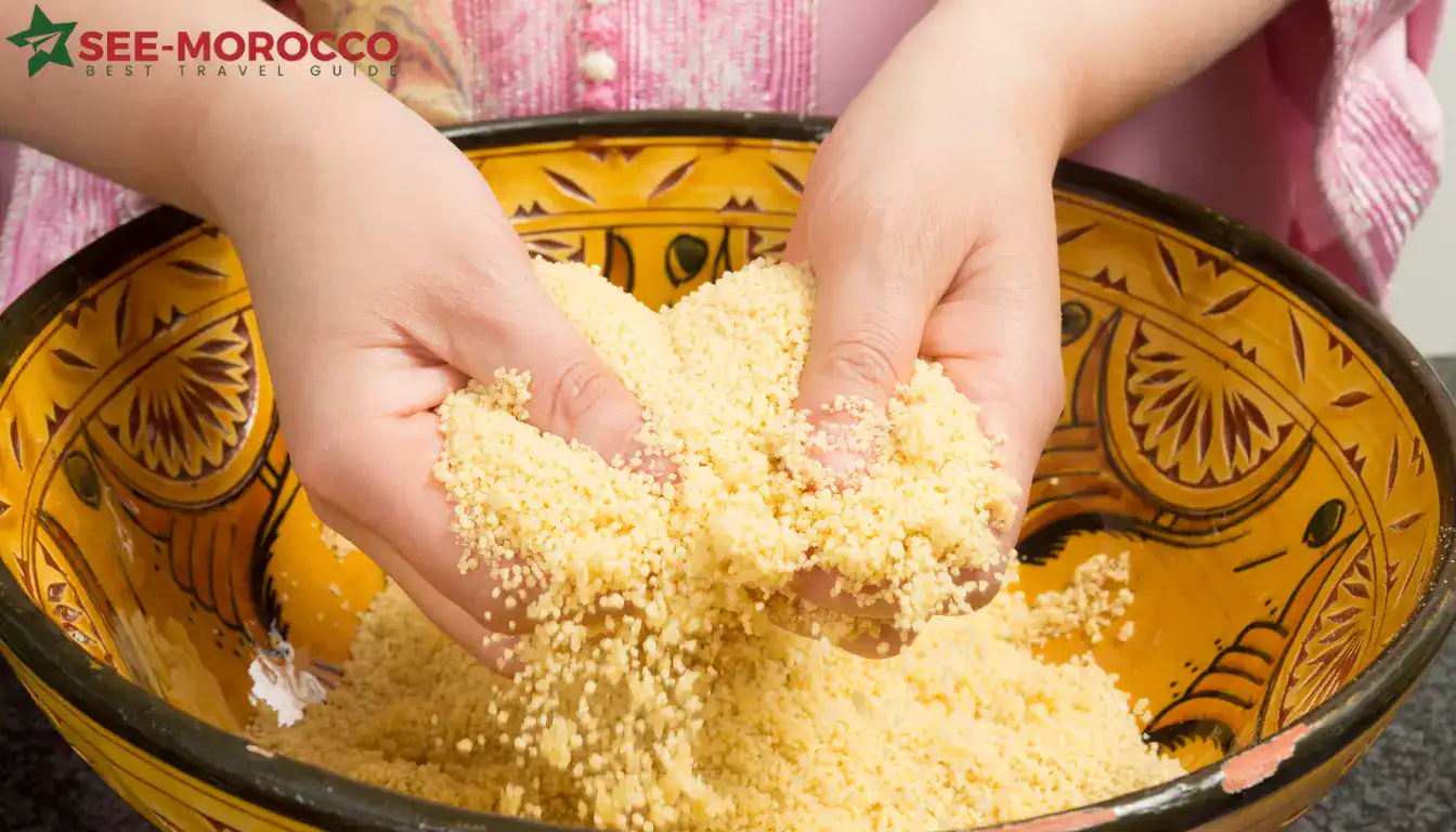 Hand-rubbing couscous grains with olive oil before steaming in a traditional gsâa bowl