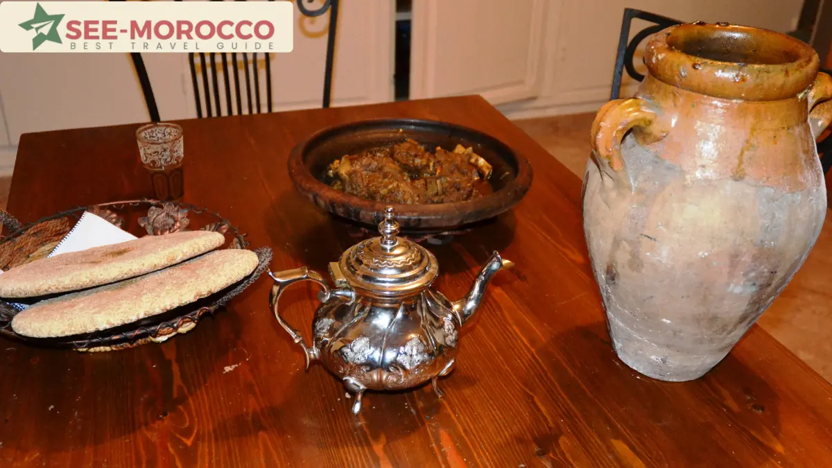 Traditional Marrakchi tanjia in a clay urn with bread and tea