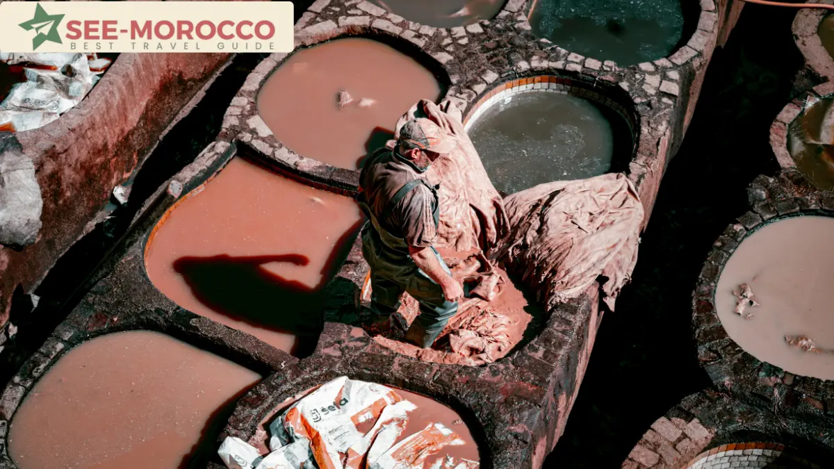 Leather worker treading hides by hand in a dye vat at Chouara Tannery