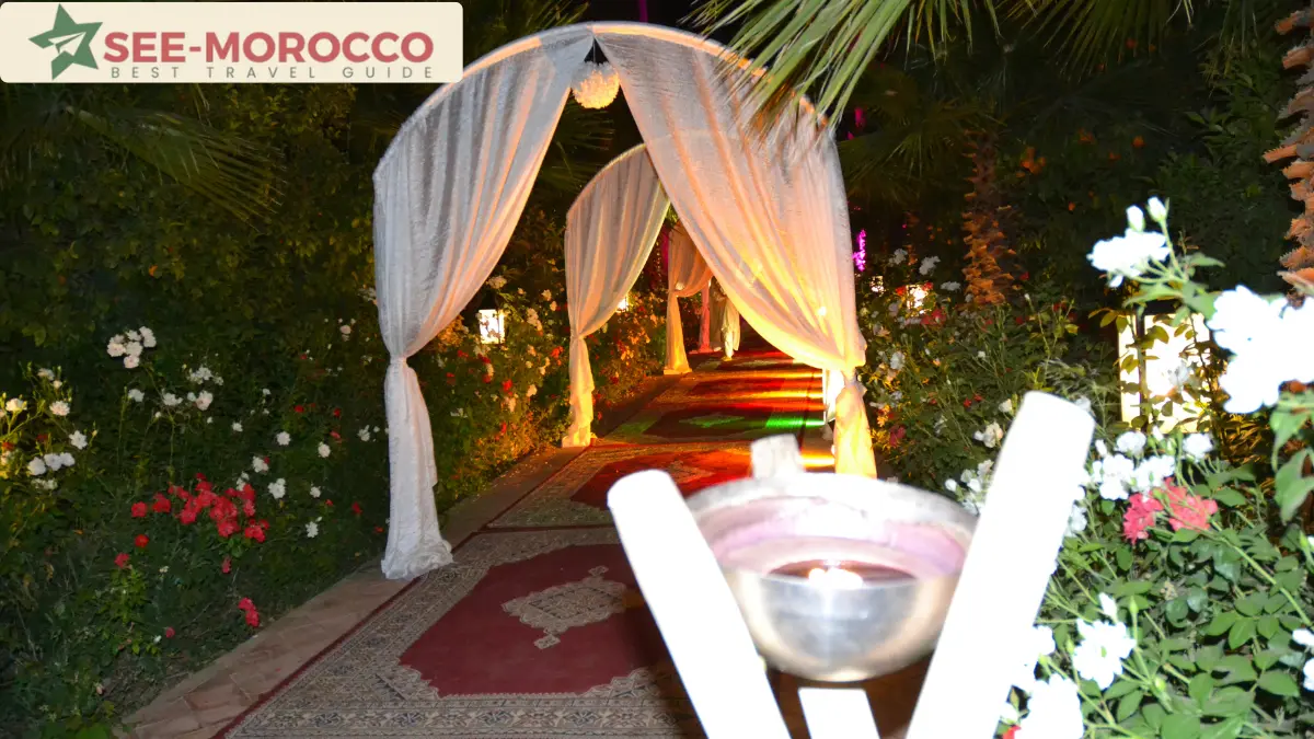 Draped fabric archways and rose petals lining a wedding venue pathway at night in Morocco