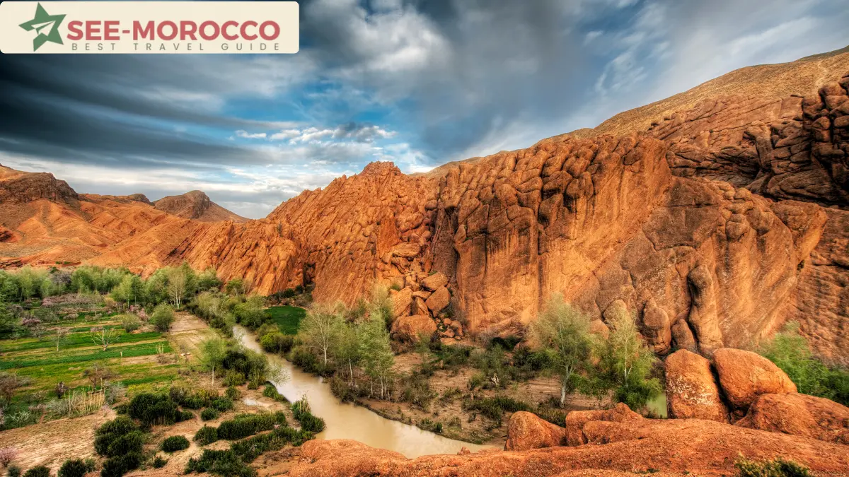 Dades River and green fields beneath the red rock walls of the gorge Morocco