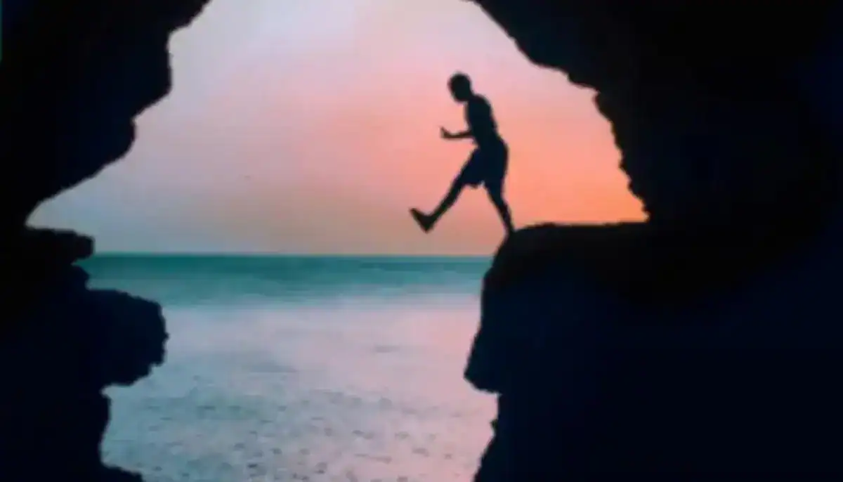 Hercules Cave Tangier — silhouette at sunset with orange sky over Atlantic Ocean