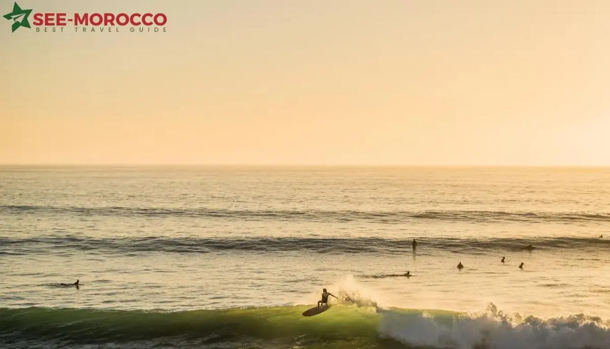 Moroccan surf culture — surfer riding wave at golden hour with lineup waiting in background