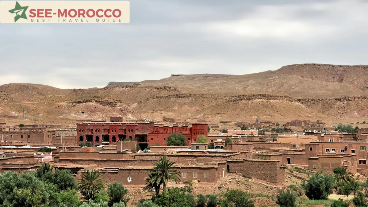 Berber village near Ouarzazate Morocco with traditional earthen architecture and Atlas Mountains in background