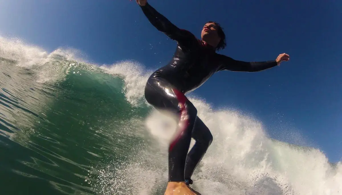 Surfer in Morocco riding green Atlantic wave close-up wetsuit