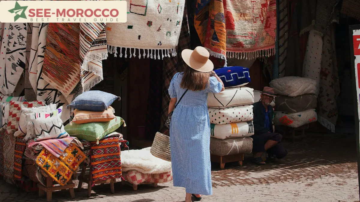 Solo female traveller browsing rugs and cushions at a Moroccan souk