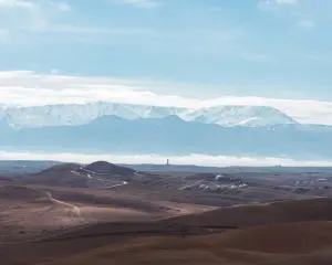 Agafay Desert Morocco — rocky stone hills with snow-capped Atlas Mountains behind