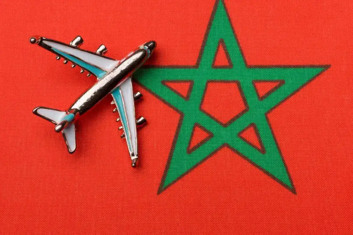 Morocco tours travel — airplane on Moroccan flag representing flights to Morocco